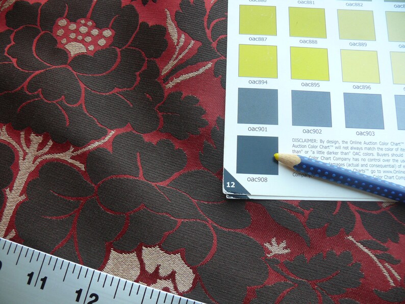 May include: Close-up of a fabric swatch with a floral pattern in shades of red, brown, and beige. A ruler is visible in the bottom left corner. A color chart with the text "Online Auction Color Chart" is visible in the top right corner.