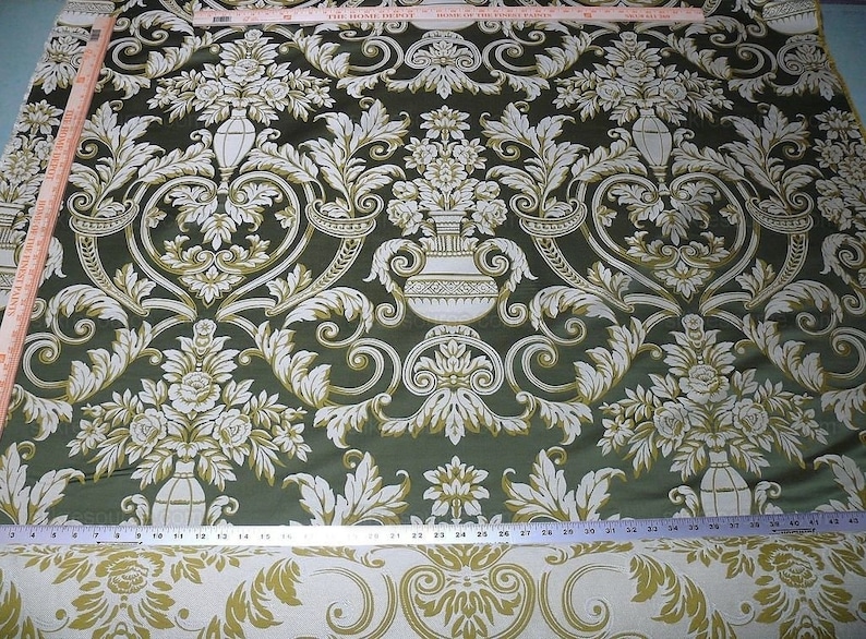 Pu&ograve; includere: Tessuto verde con un motivo damascato bianco e oro con motivi floreali e vasi decorati. Il tessuto ha una lucentezza discreta e una sensazione di lusso.