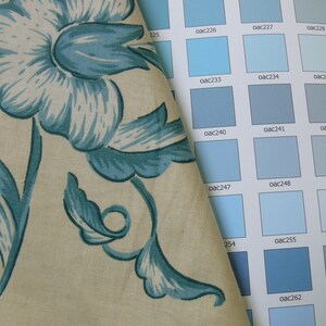 May include: A fabric swatch with a blue floral pattern is placed on top of a color chart with various shades of blue. The color chart has the color codes for each shade of blue.