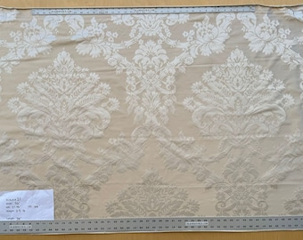 May include: A close-up of a white and beige damask fabric with a large, intricate floral pattern. The fabric is measured with a ruler, showing a width of 54 inches and a length of 59 inches.