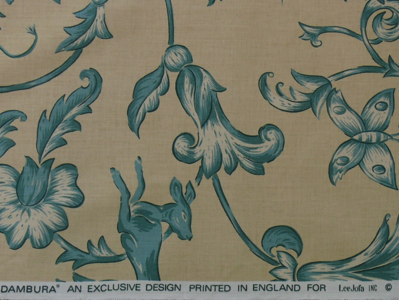 May include: A beige fabric with a teal floral pattern. The pattern includes stylized flowers, leaves, butterflies, and a deer. The fabric has the text "DAMBURA' AN EXCLUSIVE DESIGN PRINTED IN ENGLAND FOR Lee Jofa INC."