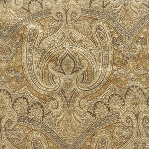 May include: A brown and gold paisley patterned fabric with a subtle shimmer. The fabric has a textured surface and a repeating pattern of intricate floral and paisley designs.