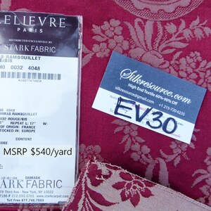 May include: A close-up of a fabric swatch with a floral pattern in shades of pink and white on a burgundy background. The fabric is labeled "Damas Rambouillet Rouge/Bis" with the design number "HO 0032 4048". The fabric is 61 inches wide and has a 17-inch repeat. It is made of 100% viscose and is priced at $540 per yard.