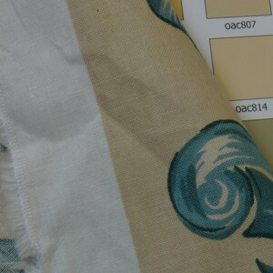 May include: Close-up of a beige fabric with a blue and white swirl pattern. The fabric is next to a color chart with the codes "oac807" and "oac814".
