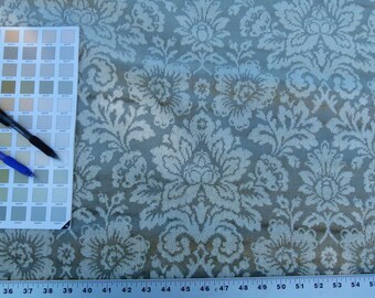 May include: A close-up of a light blue fabric with a white floral pattern. The fabric is textured and has a subtle sheen. A ruler is visible at the bottom of the image, with markings from 36 to 55.