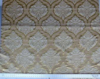 May include: Gold fabric with a white damask pattern. The pattern features a repeating design of stylized floral motifs.