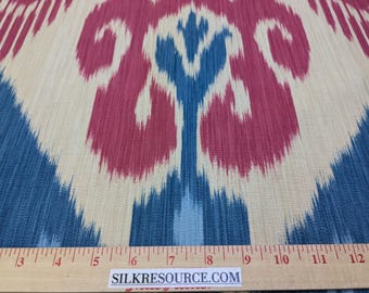 May include: Close-up of a fabric with a blue, white and red ikat pattern. The fabric is measured with a ruler that reads "SILKRESOURCE.COM".