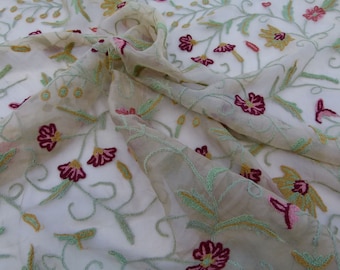 May include: A sheer fabric with embroidered floral designs in shades of green, pink, and burgundy. The fabric has a delicate, airy feel and is perfect for creating lightweight garments or accessories.