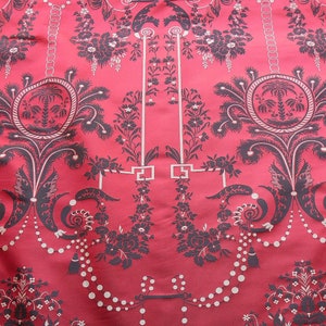 May include: Red fabric with a black and white damask pattern. The pattern features a repeating design of stylized palm trees, garlands, and floral motifs.