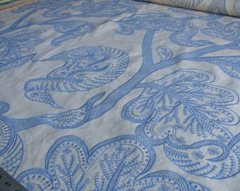May include: White fabric with a blue embroidered design of stylised leaves and birds. The fabric has a subtle texture.