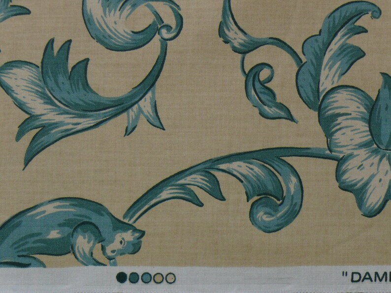 May include: A beige fabric with a blue floral pattern. The pattern features stylized leaves and flowers. The fabric has a subtle texture and a soft, natural feel.