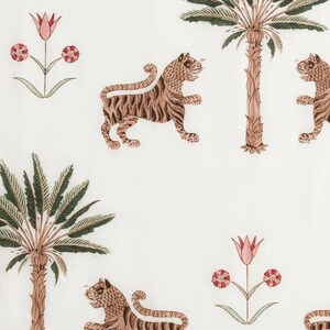 May include: White fabric with a repeating pattern of tigers, palm trees, and flowers. The tigers are brown with black stripes, the palm trees are brown and green, and the flowers are pink and red.