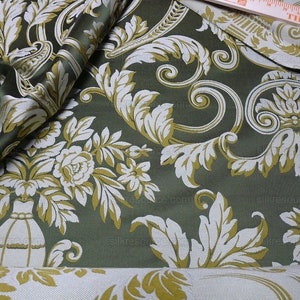 Pu&ograve; includere: Tessuto verde con un motivo damascato bianco e oro. Il motivo presenta fiori, foglie e volute stilizzate.
