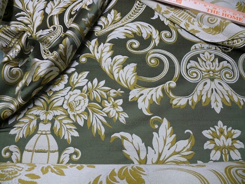Pu&ograve; includere: Tessuto verde con un motivo damascato bianco e oro. Il motivo presenta fiori, foglie e volute stilizzate.