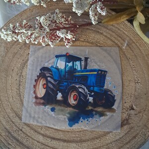 May include: A blue tractor with a yellow stripe and large tires on a watercolor background.