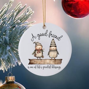 May include: White ceramic Christmas ornament with two cartoon penguins on a log. The ornament reads "A good friend is one of life's greatest blessings."