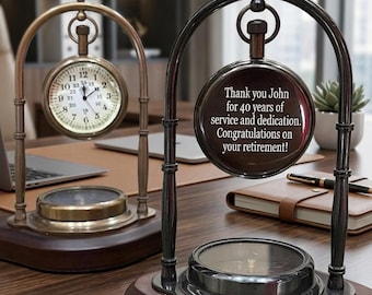 May include: Two desk clocks with dark wood bases and metal arched frames. One clock features a white face with black numerals. The other clock displays the text: Thank you John for 40 years of service and dedication. Congratulations on your retirement!