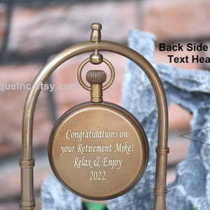 May include: A brass pocket watch with an engraved message: "Congratulations on your Retirement Mike! Relax & Enjoy 2022". The watch is on a decorative stand. The back of the watch is blank and can be engraved with a personalised message.