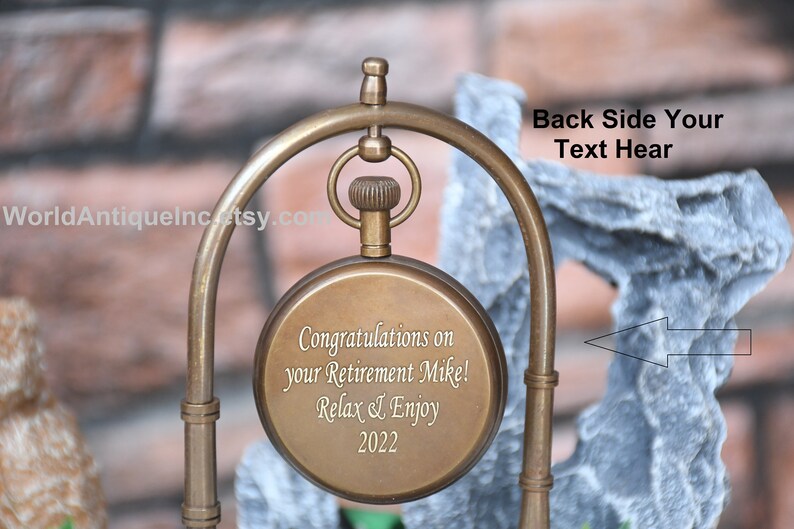 May include: A brass pocket watch with an engraved message: "Congratulations on your Retirement Mike! Relax & Enjoy 2022". The watch is on a decorative stand. The back of the watch is blank and can be engraved with a personalised message.