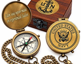 Puede incluir: Una brújula de bolsillo de latón con cadena, que presenta el emblema de la Marina de los EE. UU. en la tapa y la cita "Calm seas never made an experienced Sailor." grabada en el interior. Detrás hay una caja de madera con un logo de ancla USN.