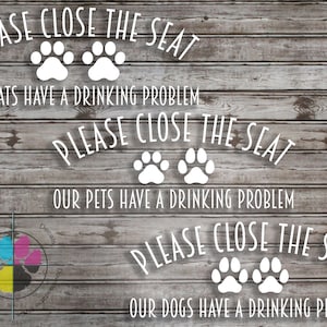Könnte beinhalten: Drei weiße Vinyl-Aufkleber mit Pfotenabdrücken und dem Text "PLEASE CLOSE THE SEAT" mit einem anderen Tier unter jedem Schild: "OUR CATS HAVE A DRINKING PROBLEM", "OUR PETS HAVE A DRINKING PROBLEM" und "OUR DOGS HAVE A DRINKING PROBLEM".