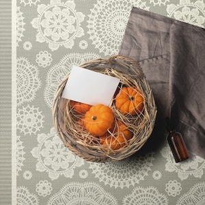 May include: A basket filled with small orange pumpkins and straw, sitting on a grey and white patterned rug with a white card and a small brown bottle. The rug has a white border and the text "CHINUA FLOORING" in a black rectangle.