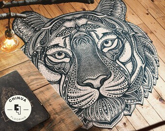 May include: Black and white detailed illustration of a tiger's face, printed on a cork surface. The tiger's face is surrounded by a decorative border.