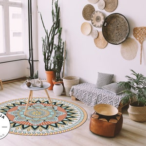 May include: A round, colorful mandala rug with a blue, yellow, orange, and red design. The rug is in a living room with a couch, a coffee table, and plants.