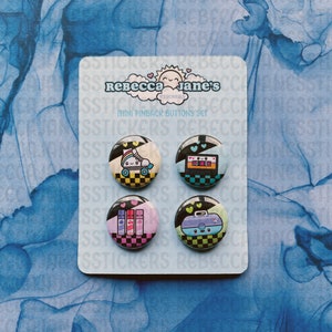 May include: Set of four 1 inch pinback buttons with a black and white checkered background. The buttons feature a roller skate, a cassette tape, a makeup palette, and a suitcase with a smiling face.