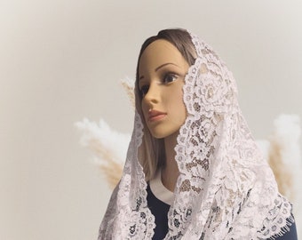 May include: White lace mantilla with a floral pattern. The lace is delicate and has a soft, flowing texture.