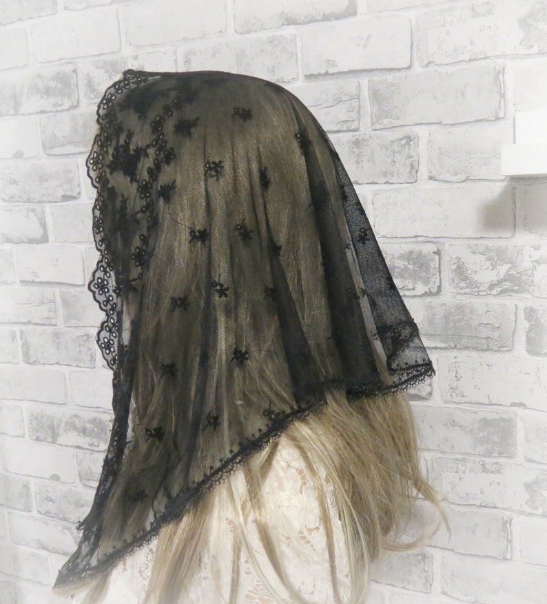 Peut inclure: Voile en dentelle noire avec un motif floral d&eacute;licat. Le voile est transparent et a un bord festonn&eacute;.