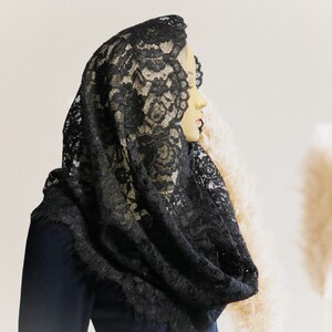 May include: A black lace mantilla, a traditional Spanish head covering, with intricate floral patterns.