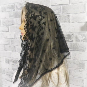 Peut inclure: Mantille en dentelle noire avec une d&eacute;licate broderie florale. La mantille est faite d'un tissu transparent et a un bord festonn&eacute;.