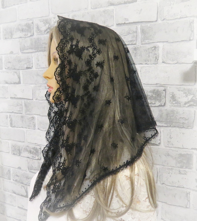 Peut inclure: Mantille en dentelle noire avec une d&eacute;licate broderie florale. La mantille est faite d'un tissu transparent et a un bord festonn&eacute;.