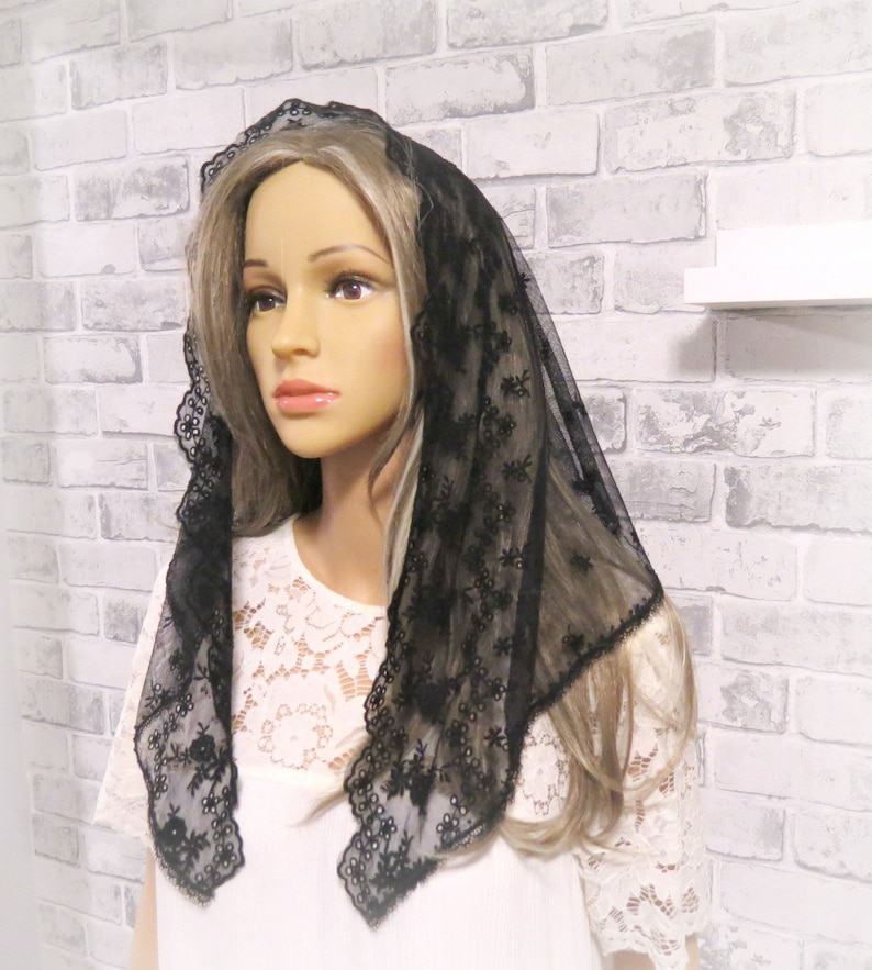 Peut inclure: Mantille en dentelle noire avec broderie florale. La mantille est transparente et d&eacute;licate, avec un bord festonn&eacute;.