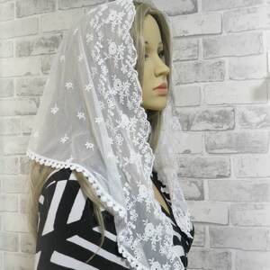 Peut inclure: Voile en dentelle blanche avec broderie florale et bord festonn&eacute;. Le voile est port&eacute; par une personne aux cheveux blonds. Le texte "Taille M." est visible dans le coin sup&eacute;rieur droit de l'image.