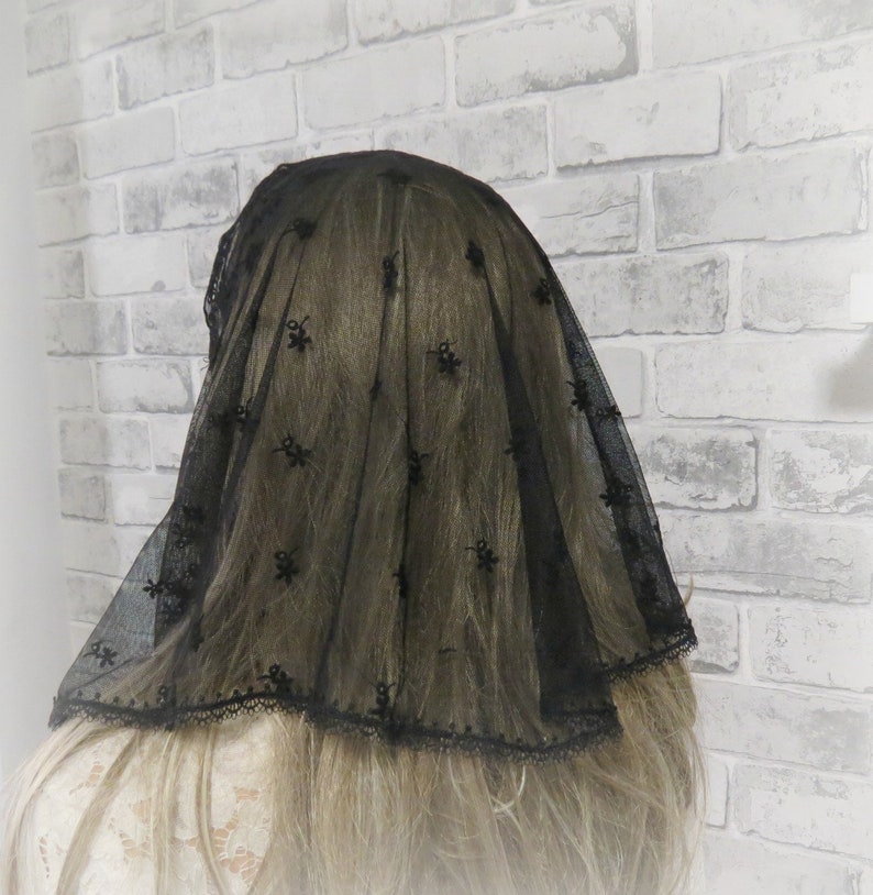 Peut inclure: Voile en dentelle noire avec un motif floral. Le voile a un bord festonn&eacute; et est fait d'un tissu transparent.
