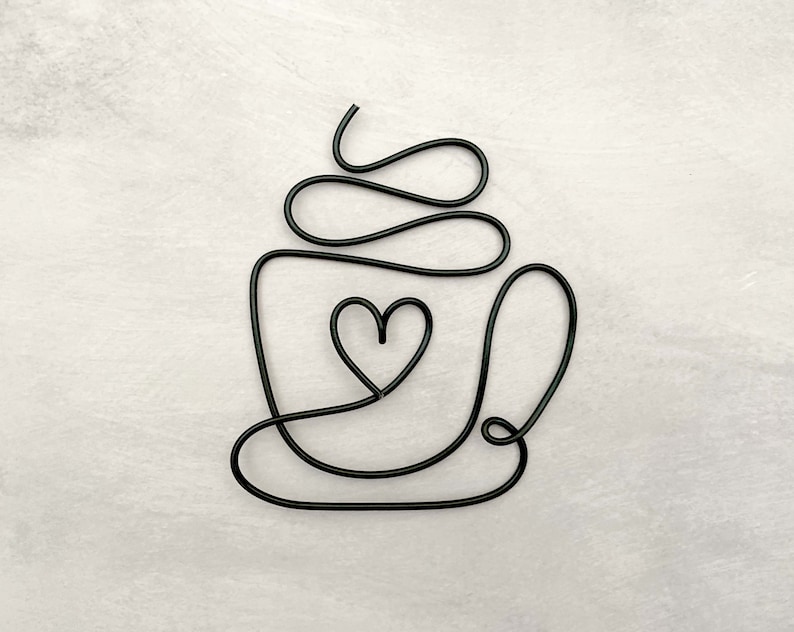 Puede incluir: Escultura de alambre negro de una taza de caf&eacute; con un coraz&oacute;n en el centro. La taza tiene un dise&ntilde;o de espiral en la parte superior.