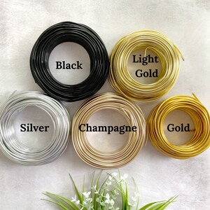 May include: Six spools of wire in different colors: black, silver, champagne, light gold, and gold.