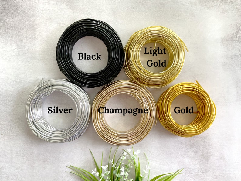 May include: Six spools of wire in different colors: black, silver, champagne, light gold, and gold.