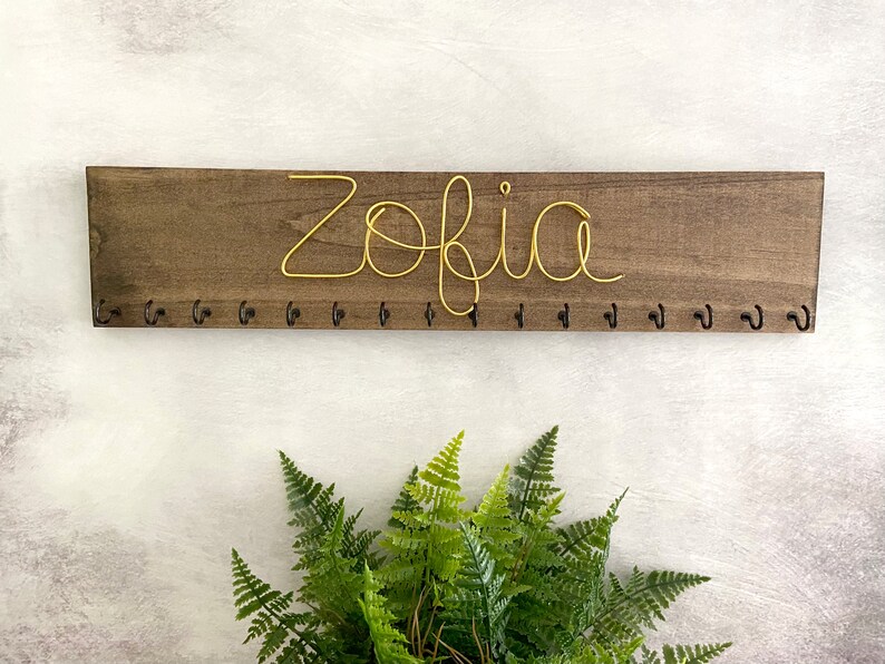 May include: A weathered wooden sign displaying the words "Welcome to our porch" in white. The sign has a distressed appearance, ideal for adding a touch of rustic charm to a porch or garden.
