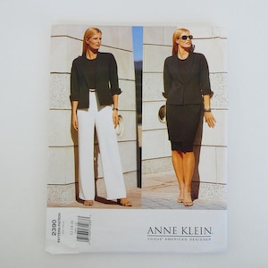 May include: A sewing pattern featuring two women modeling business attire. One model wears a black jacket with white pants, the other a black skirt suit. The pattern is labeled "ANNE KLEIN, VOGUE AMERICAN DESIGNER."