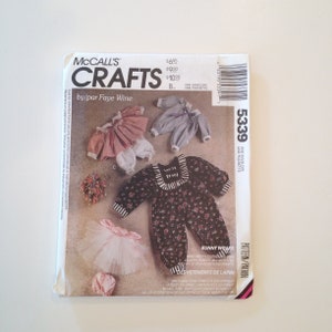 May include: A McCall's Crafts sewing pattern envelope featuring various bunny wrap clothing designs. The envelope includes illustrations of outfits, including a floral jumpsuit, a tutu, and striped tops. The text on the envelope reads "Bunny Wraps."