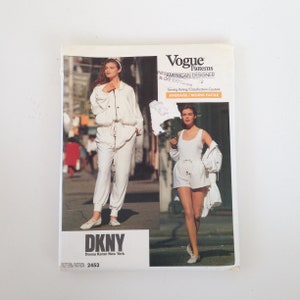 Pode incluir: Um padrão de costura Vogue Patterns para um conjunto de macacão e shorts brancos da Donna Karan New York. O número do padrão é 2453. A classificação de costura é média.