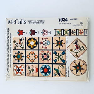 May include: A vintage McCall's printed pattern with transfer, featuring colorful geometric and floral designs. The pattern includes instructions for Pennsylvania hex motifs for felt or fabric applique, or crewel embroidery for pillows and wall hanging. The package is labeled "7034".