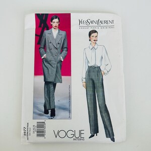 Może przedstawiać: Koperta z wykrojem krawieckim Vogue Paris Original dla projektu Yves Saint Laurent 2477. Z przodu znajduje się zdjęcie szarego dwurzędowego płaszcza ze spodniami oraz ilustracja modowa przedstawiająca białą bluzkę i spodnie.