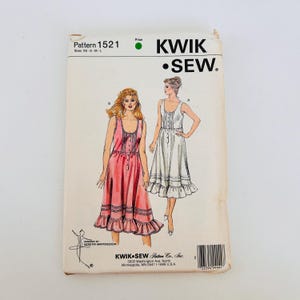May include: A Kwik Sew pattern envelope 1521 featuring illustrations of two sleeveless dresses with button-front bodices and ruffled hems. The pattern includes sizes XS, S, M, and L. The text includes Pattern 1521, Kwik Sew, and company details.