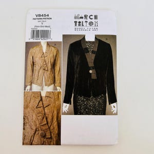 May include: A sewing pattern envelope for Marcy Tilton Wearable Art V8454, size Y (Xsm-Sml-Med). The front displays two jacket variations: a tan textured jacket with a single button and a black jacket with a textured lapel and single button closure.