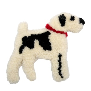 May include: A plush dog toy in a standing pose, featuring a cream-colored body with black spots and a red collar. The dog's head and tail are detailed with black accents, creating a playful and inviting design.
