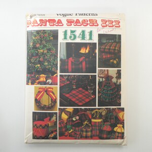 May include: Vogue Patterns Santa Pack #1541 sewing pattern featuring a red and green plaid design. The pattern includes instructions for making a Christmas tree, wreath, stockings, and other holiday decorations.